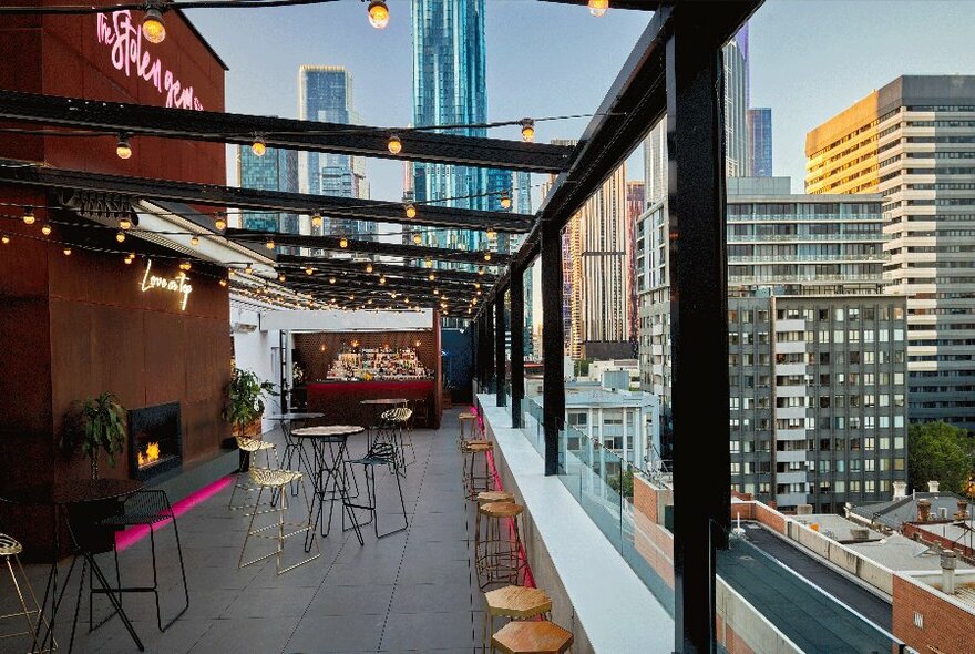A rooftop bar with a clear view of the Melbourne city skyline.