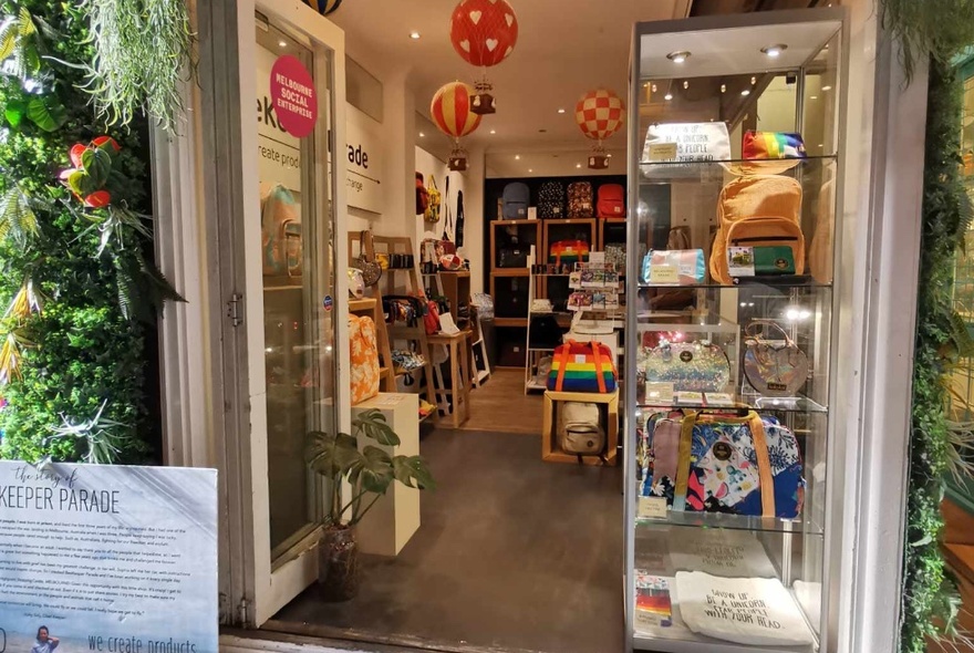 Looking into a shop door and window, filled with displays of colourful products and gifts.