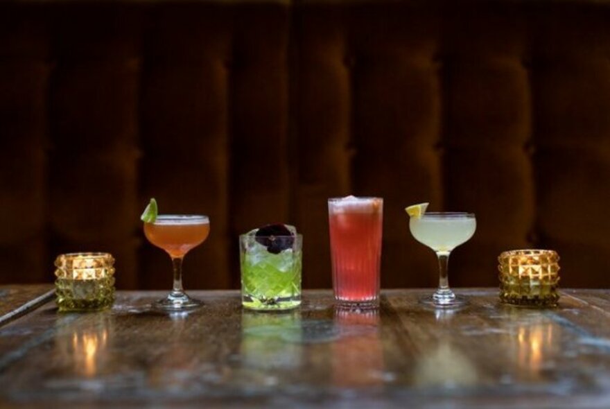 A row of cocktails on the bar.