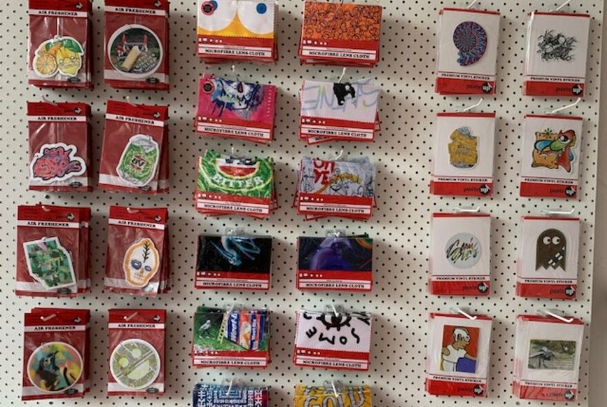 Wall display of many car air fresheners and/or magnets with different street art designs on them.