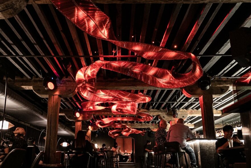 Red lighting that appears as a ceiling thread against a dark background. 