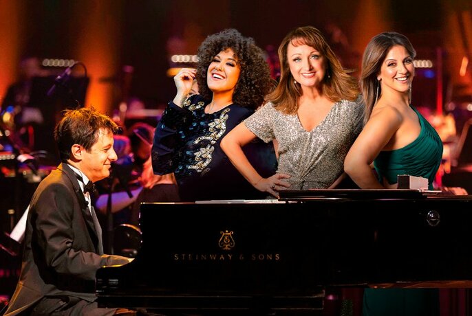 Caroline O'Connor, Silvie Paladino and Casey Donovan standing behind a piano played by John Foreman.