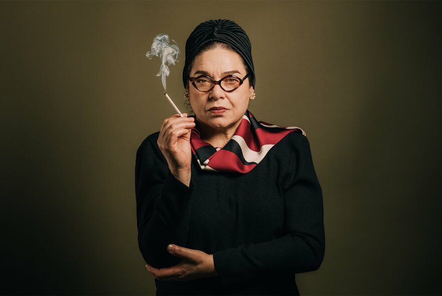 Greek woman in black, smoking a cigarette.