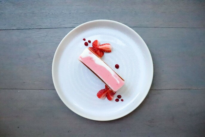 Pink and white dessert with strawberries.