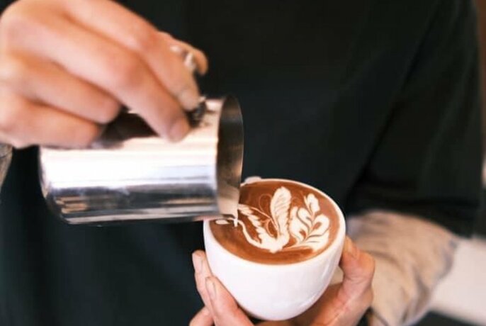 Barista pouring a coffee with a swan latte art
