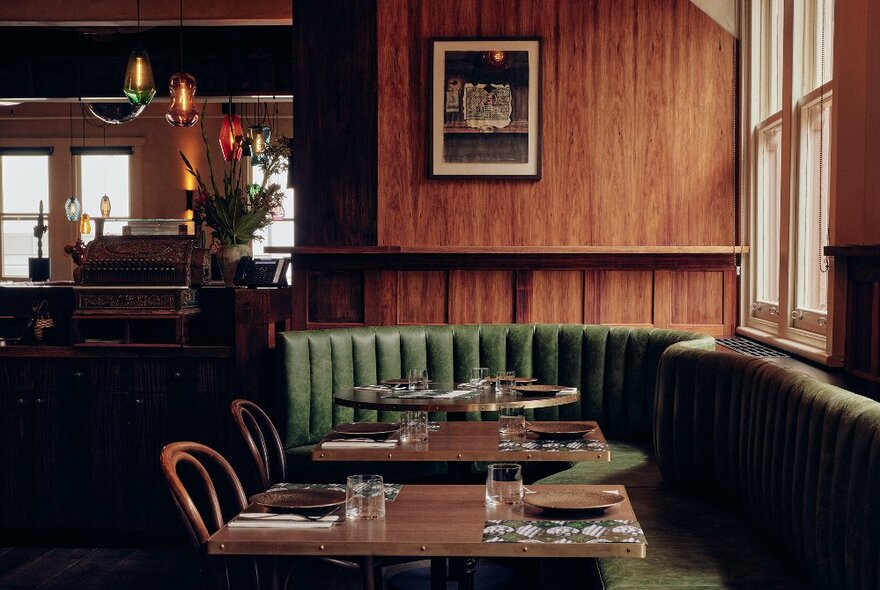Inside a restaurant with wooden walls and a green booth