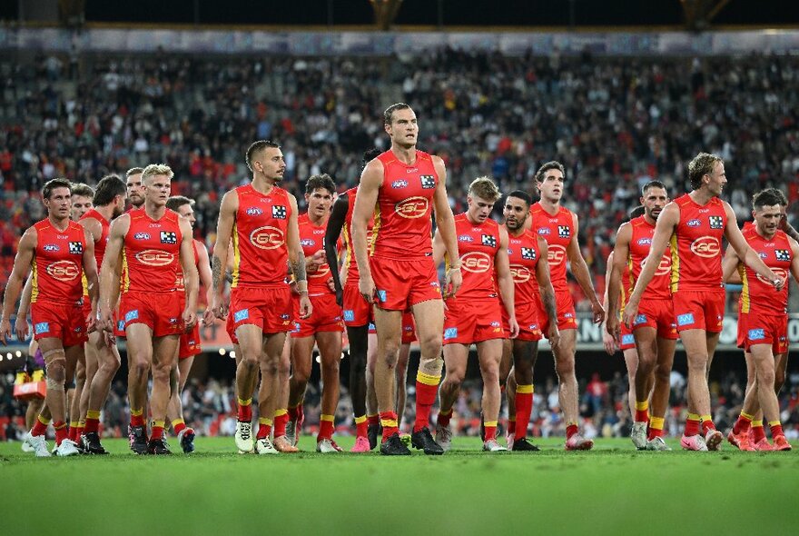 Gold Coast SUNS AFL football team walking onto the ground during a match.