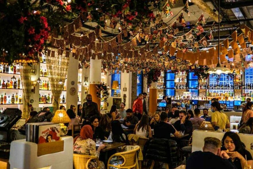 Bunting hanging from the ceiling of a busy Italian restaurant