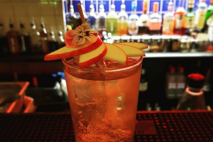 Cocktail with garnish of apple slices.
