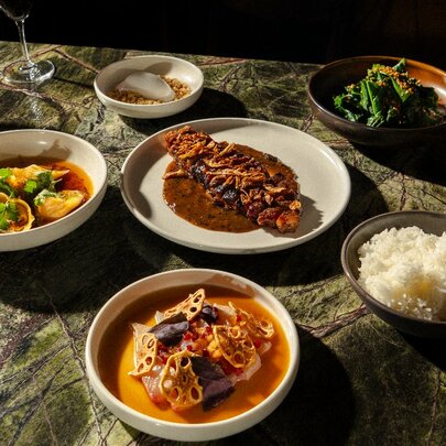A selection of restaurant dishes including fish and curries.