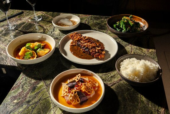 A selection of restaurant dishes including fish and curries.