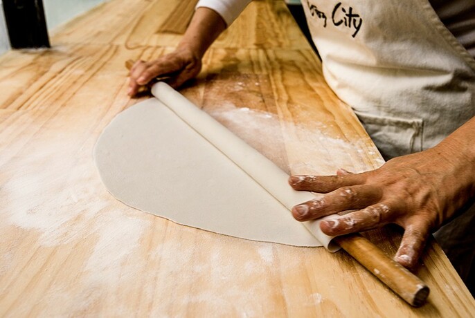 Rolling gözleme pastry by hand.