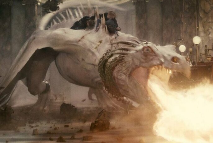 Dragon breathing fire in a movie still from Harry Potter.