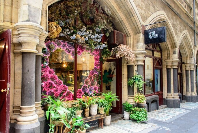 Floral window display of florist in classical Victorian stone building.