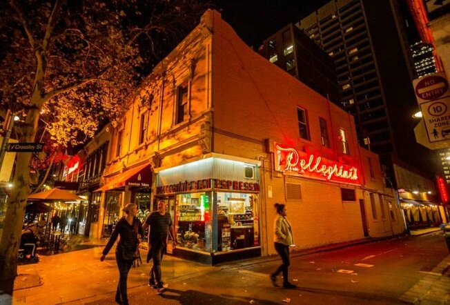 A corner restaurant with a red neon sign on the side