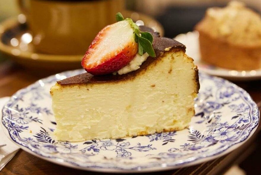 A slice of cheesecake on a blue and white plate.
