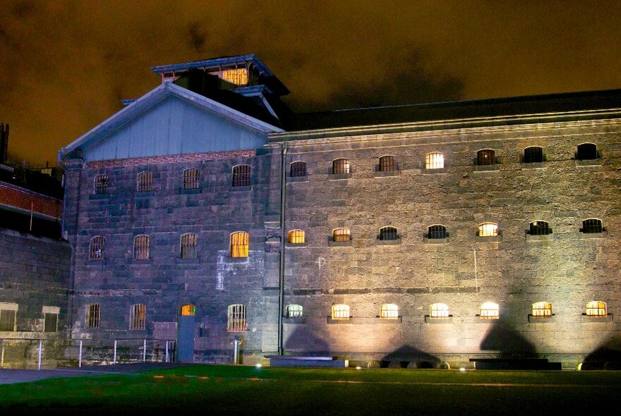 The exterior of a gaol building at night.