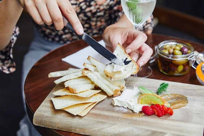 Person serving themselves from cheese platter.