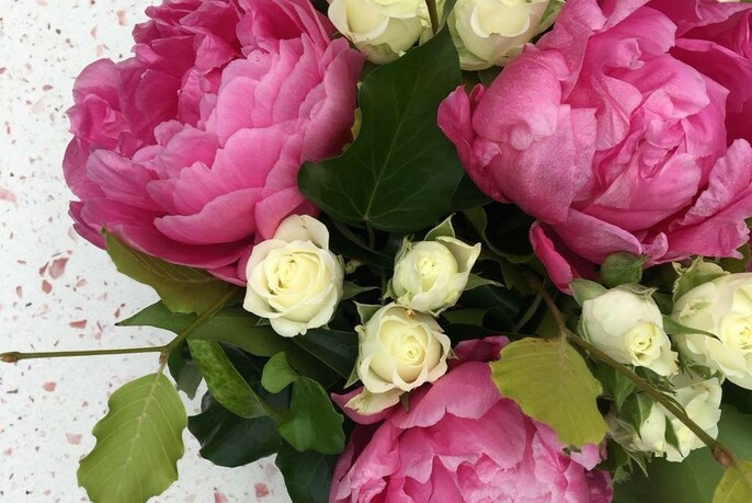 Bunch of small white roses and large pink peony roses.