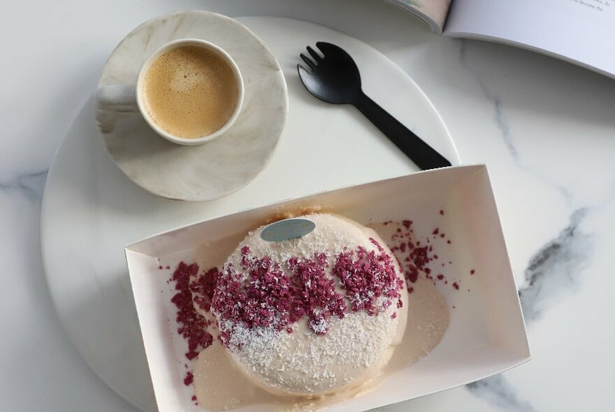 A coffee and a soufflé dessert with a berry dusting  