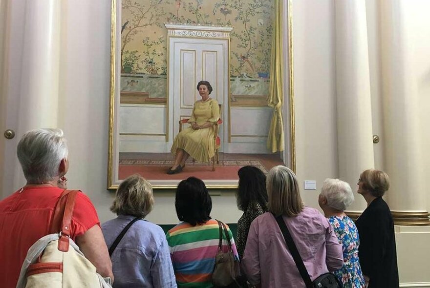 Tour participants gazing at a painting of Queen Elizabeth II.