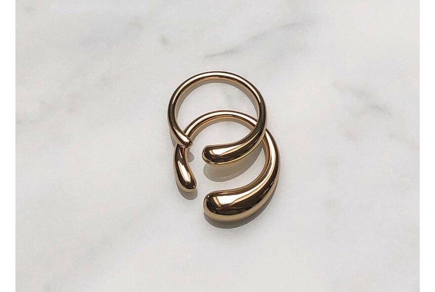Gold hoop earrings on a marble background.