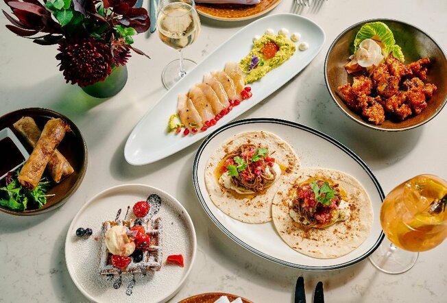 Restaurant dishes including tacos, kingfish, fried chicken and waffles.