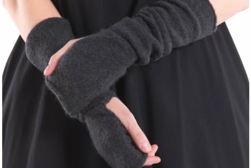 Models hands and arms shot front on wearing the Et Al Glove's in charcoal, posed with one hand on opposite arm.