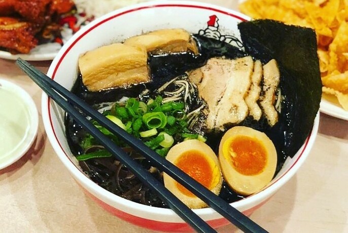 Bowl of Japanese ramen noodle soup with boiled egg, tofu and dried seaweed.