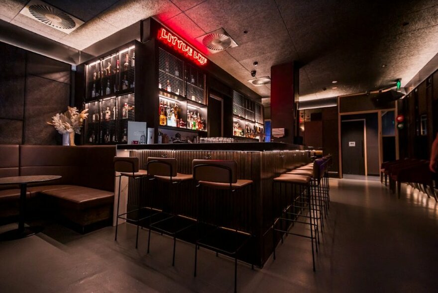 The Little LKF Bar showing darkened central bar, high stools and soft lighting.