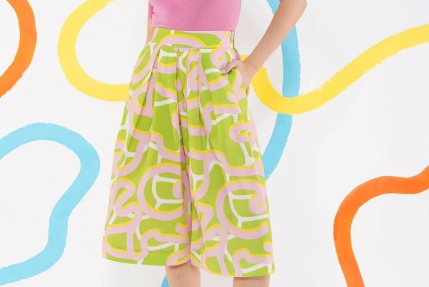 A woman is wearing a pair of lime green and pink skorts
