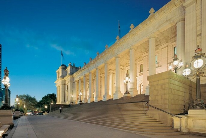 Columns and building of Parliament House lit at night.