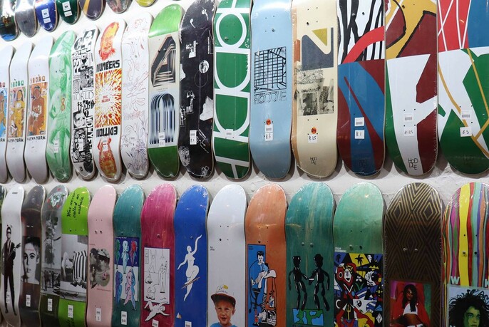 Large range of skateboards for sale displayed on a shop wall.