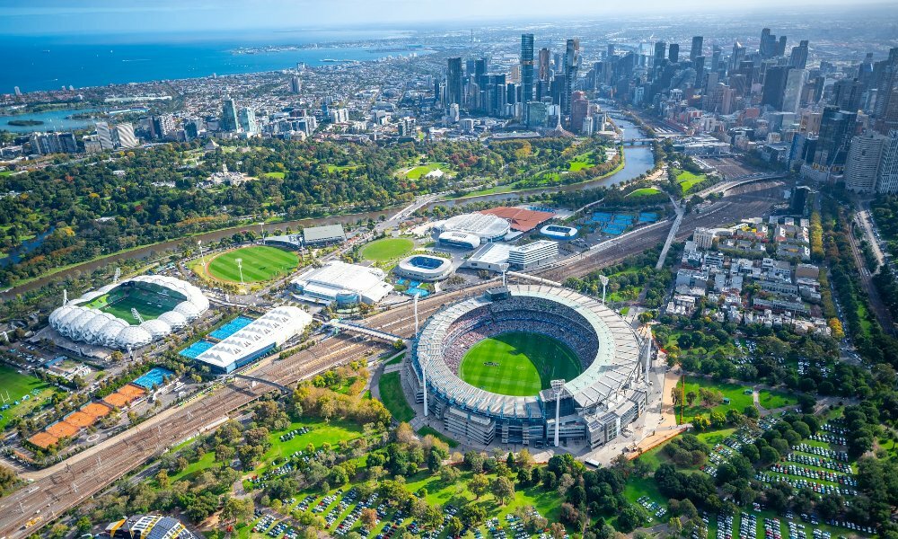 An aerial shot of Melbourne city with the MCG in the foreground on a sunny day.