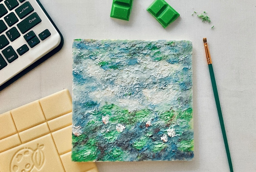 Square painted with green landscape, green paintbrush to right, green squares above, keyboard to right.