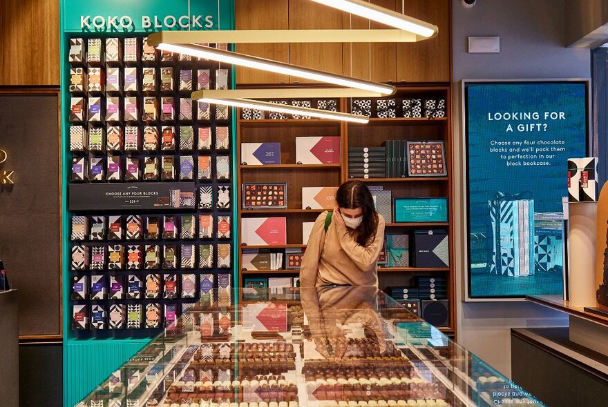 A woman browsing in a chocolate shop. 