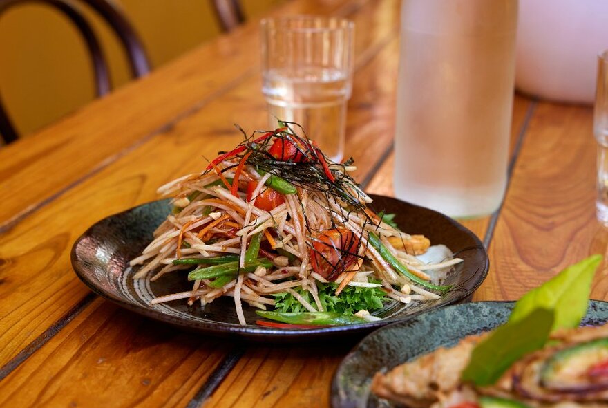 A papaya salad on a restaurant table.