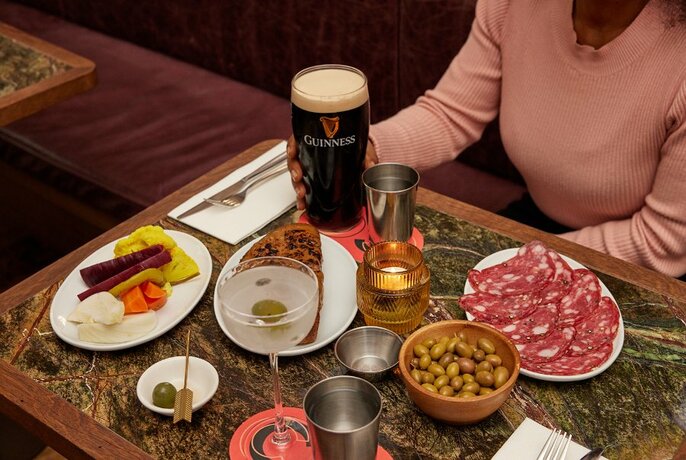 A table set with Guinness, a martini and bar snacks. 