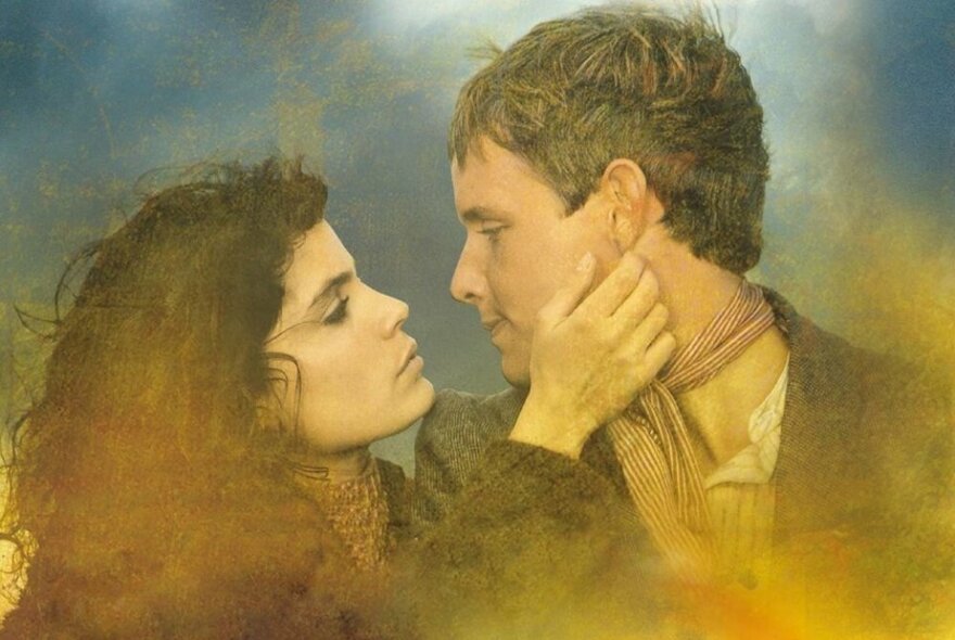 A still from the movie 'The Man from Snowy River' depicting the actors Sigrid Thornton and Tom Burlinson looking at each other with affections, in profile.