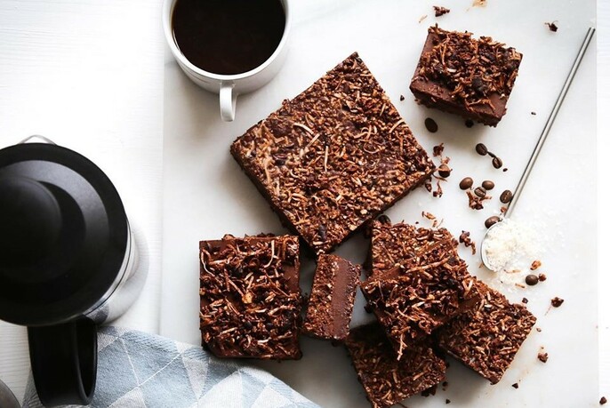Chocolate brownies with shredded coconut and a cup of coffee.