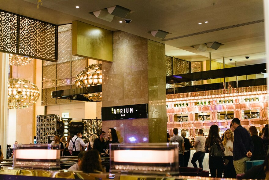Interior view of Atrium Bar with patrons gathered in groups. 