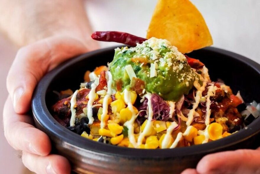 Bowl of Mexican salad with guacamole and corn.