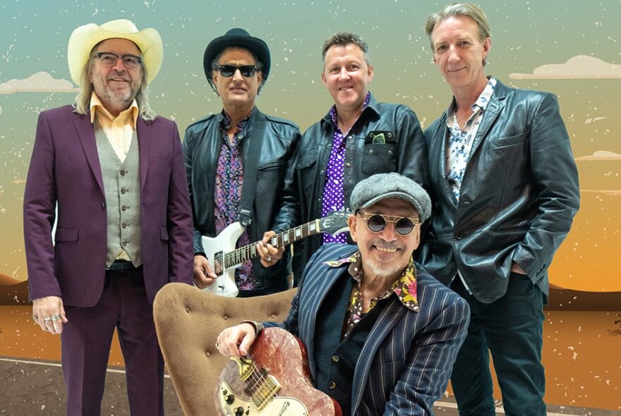 Joe Camilleri and The Black Sorrows posing in suits and in front of a fake desert background. 