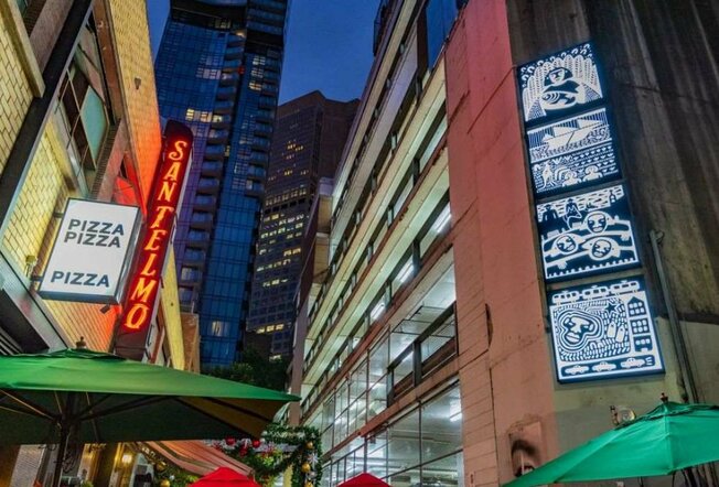 Neon signs and artworks in a laneway
