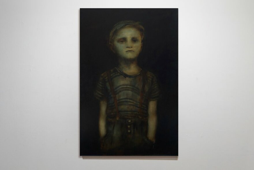 Artwork of a child, blurred against a dark background, hanging on a white gallery wall.