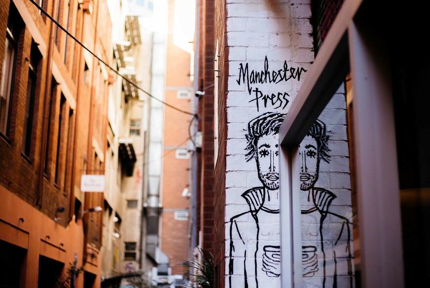 Street Art figure of a man advertising Manchester Press cafe.