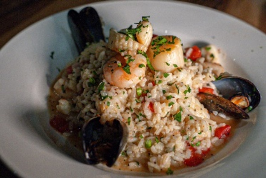 A dish of seafood risotto with mussels, prawns and octopus.
