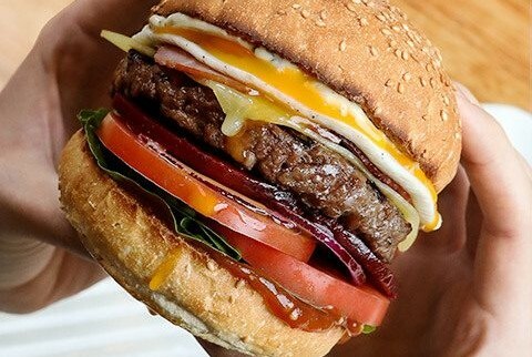 Burger with meat, tomato and cheese.