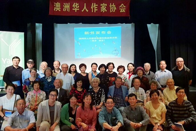 The Australian Chinese Writing Association group posed under a Chinese banner and wall slide.