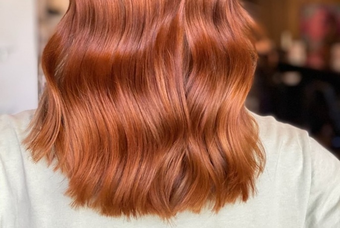 Copper-coloured wavy hair seen from behind.